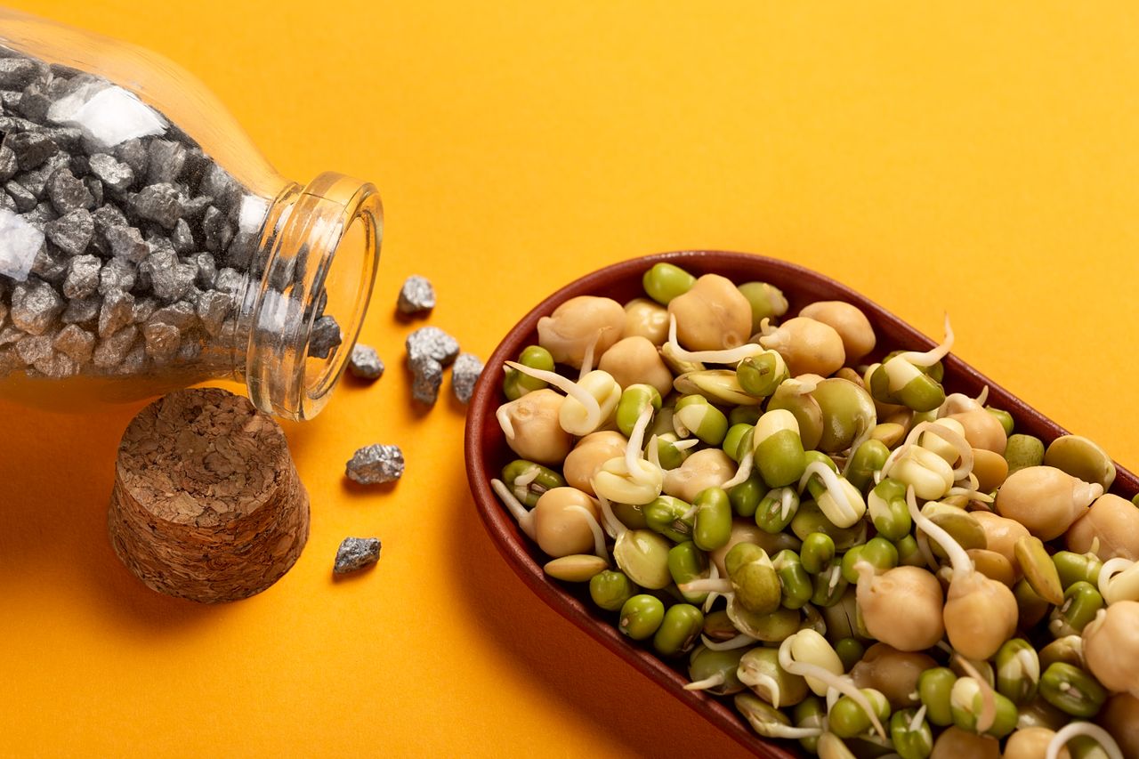 Home Healthy sprouted chickpeas and beans with iron nuggets on a vibrant yellow backdrop.