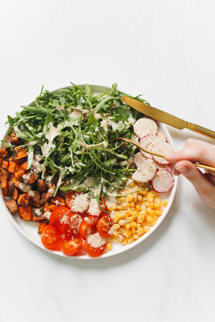 Home A vibrant salad with arugula, cherry tomatoes, radish, and corn, perfect for a healthy meal.